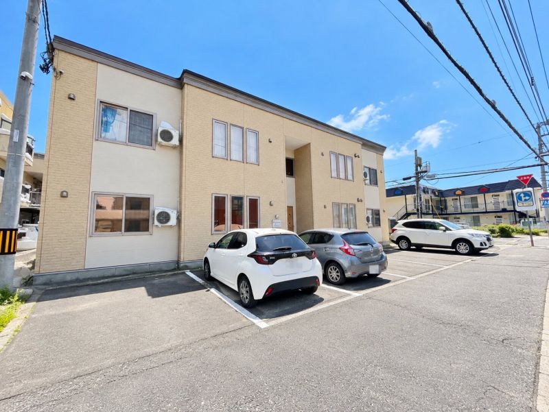 夏の陽光と集合住宅の駐車場